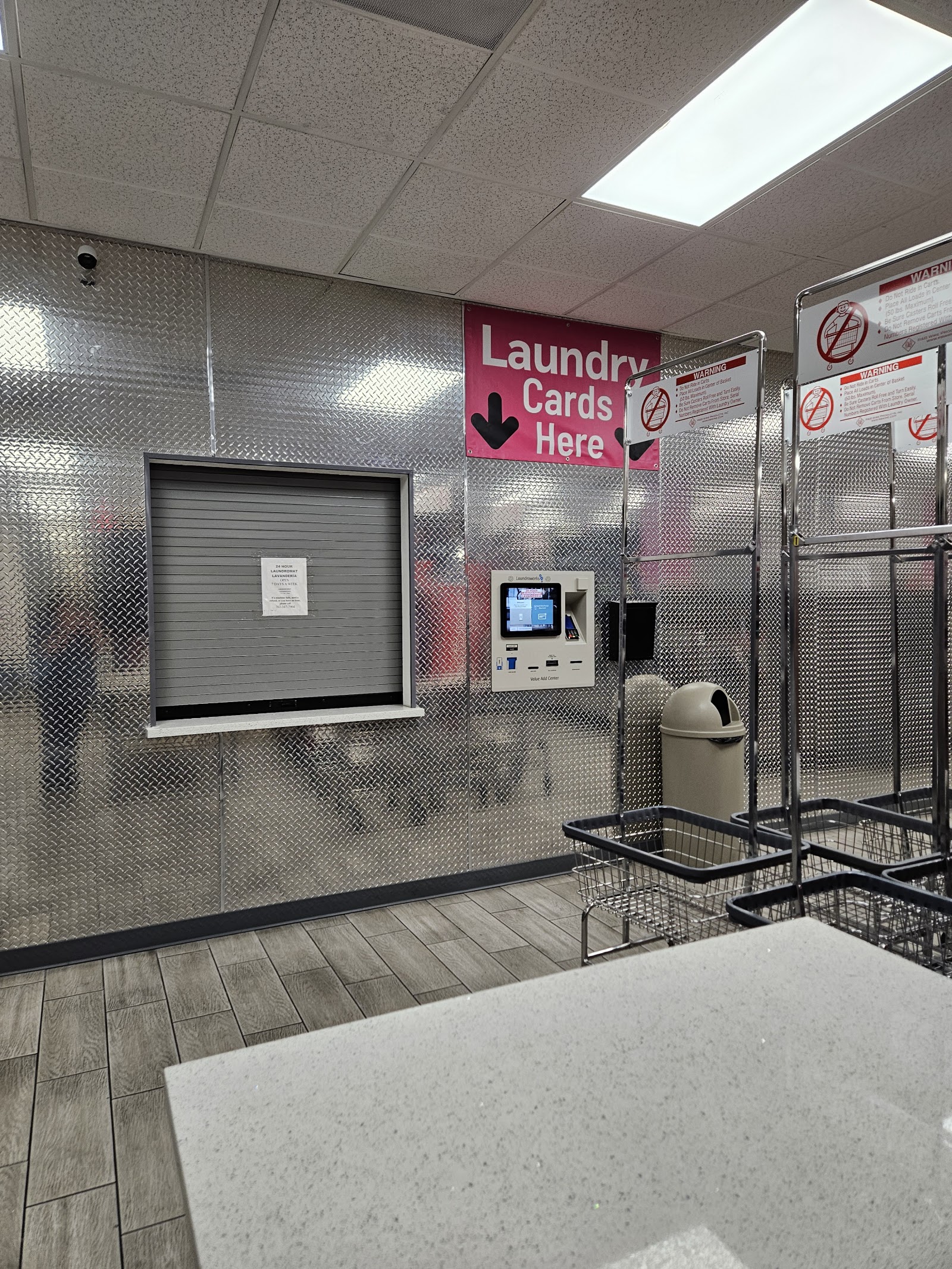 Interior with laundry card kiosk, carts, and a Laundry Cards Here sign